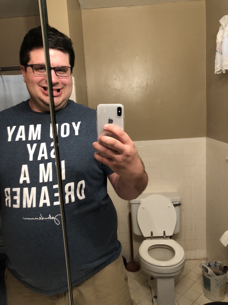 Shawn Lopp taking a bathroom mirror photo with a white iPhone