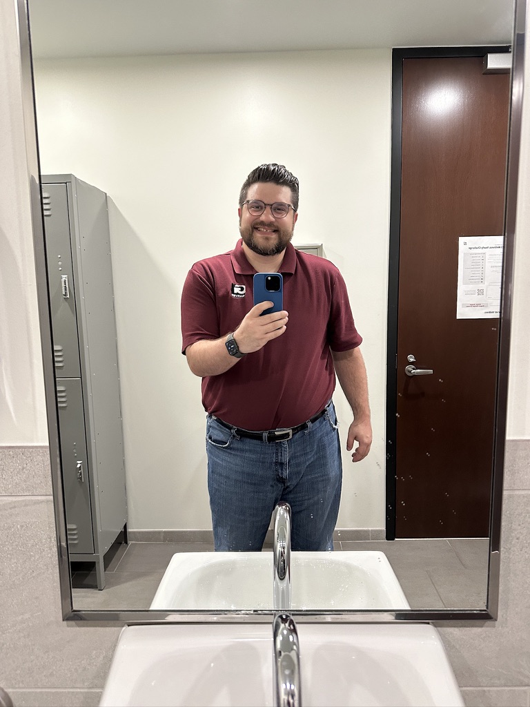 Shawn Lopp smiling in a mirror photo with a blue iPhone