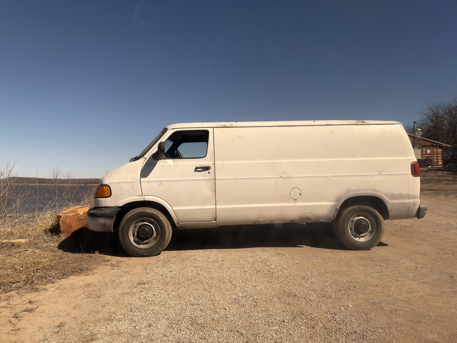 Side profile of the white prop van beside the lake