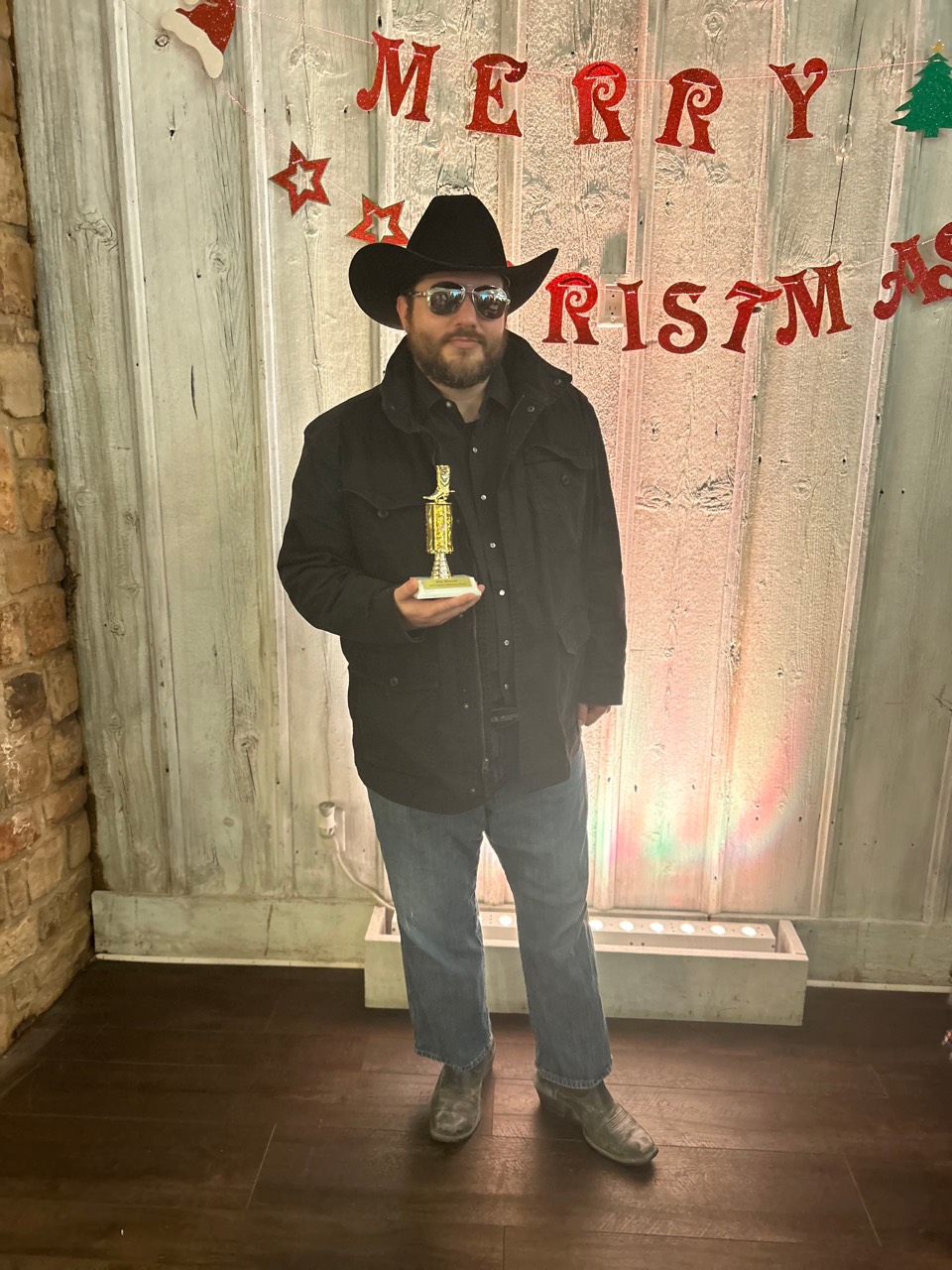 Shawn Lopp wearing a cowboy hat and holding a trophy