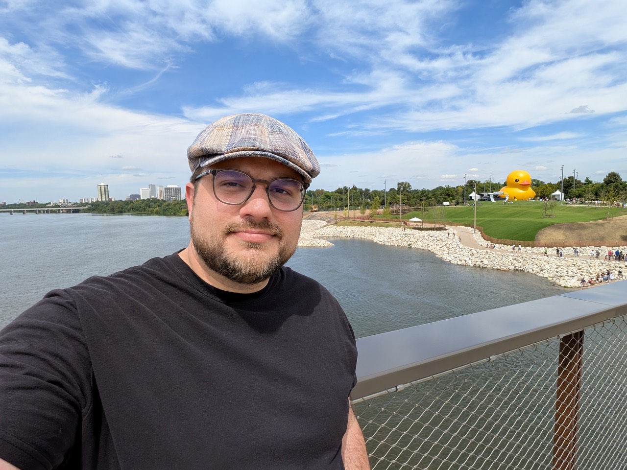 Shawn Lopp by a river with a large yellow duck in the background